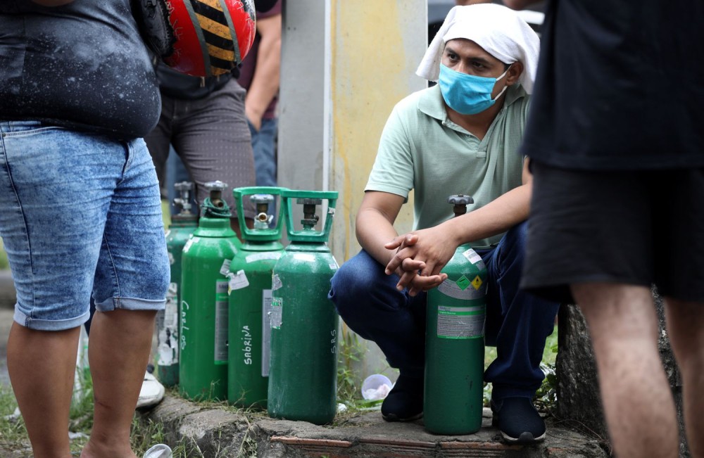 Parentes de pacientes hospitalizados ou recebendo assistência médica em casa, a maioria com Covid-19, fazem fila para comprar oxigênio e encher cilindros em uma empresa privada em Manaus. Imagem - BRUNO KELLY / REUTERS. 